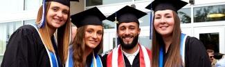 Four students in their graduation regalia at Commencement